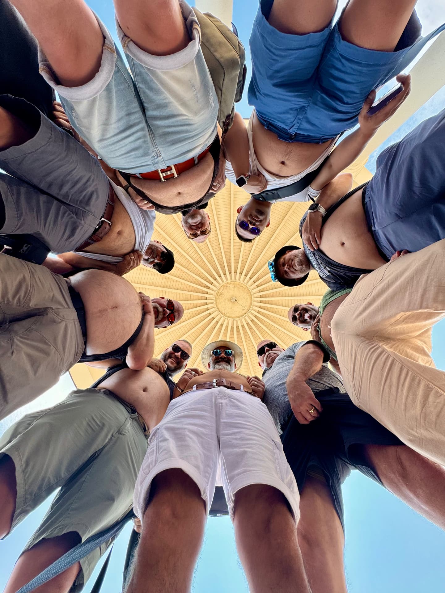 Group of friends huddled in a circle looking down at the camera