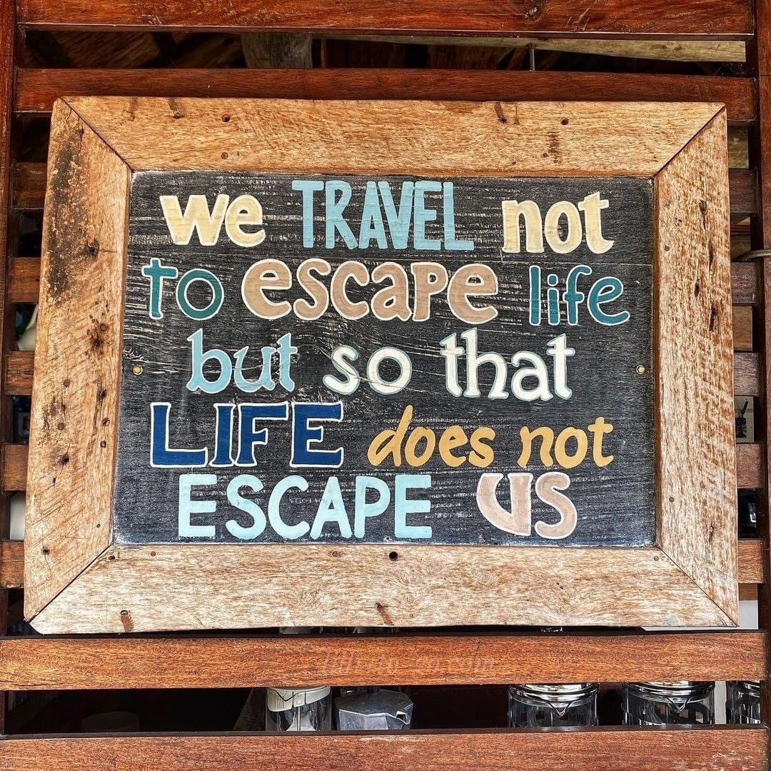 Sign reading: We travel not to escape life but so that life does not escape us