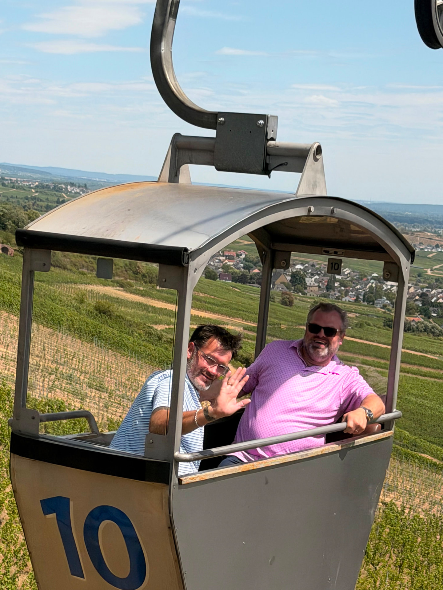Two of our travelers waving from the Rüdesheim cable car above the vineyards