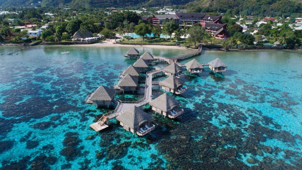 Aerial view of a Tahitian lagoon resort with overwater bungalows above turquoise water