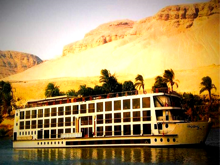 The MS Nile Dolphin sailing the Nile with desert cliffs behind