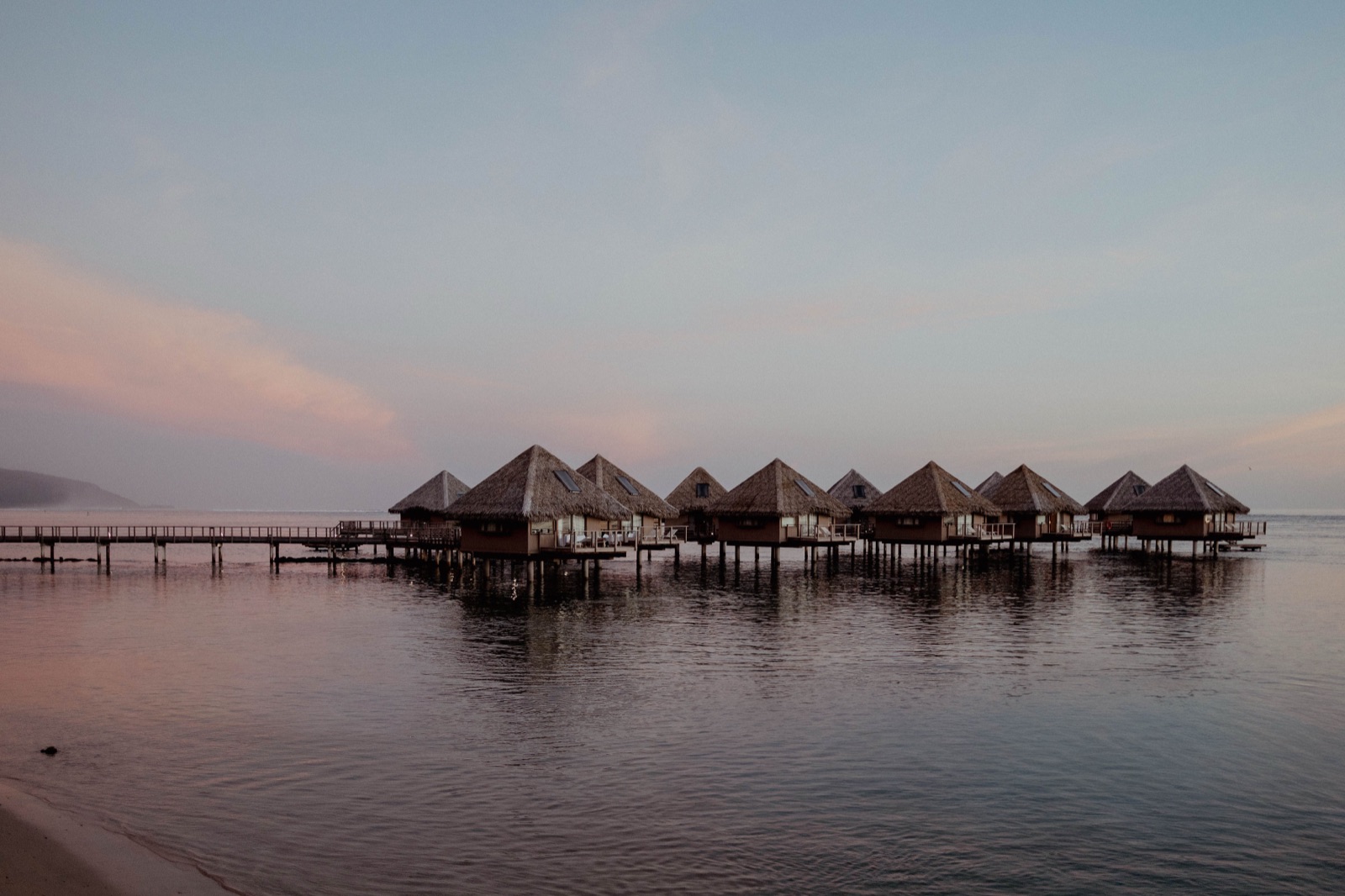 Overwater bungalows at Tahiti Lagoon Resort at sunset